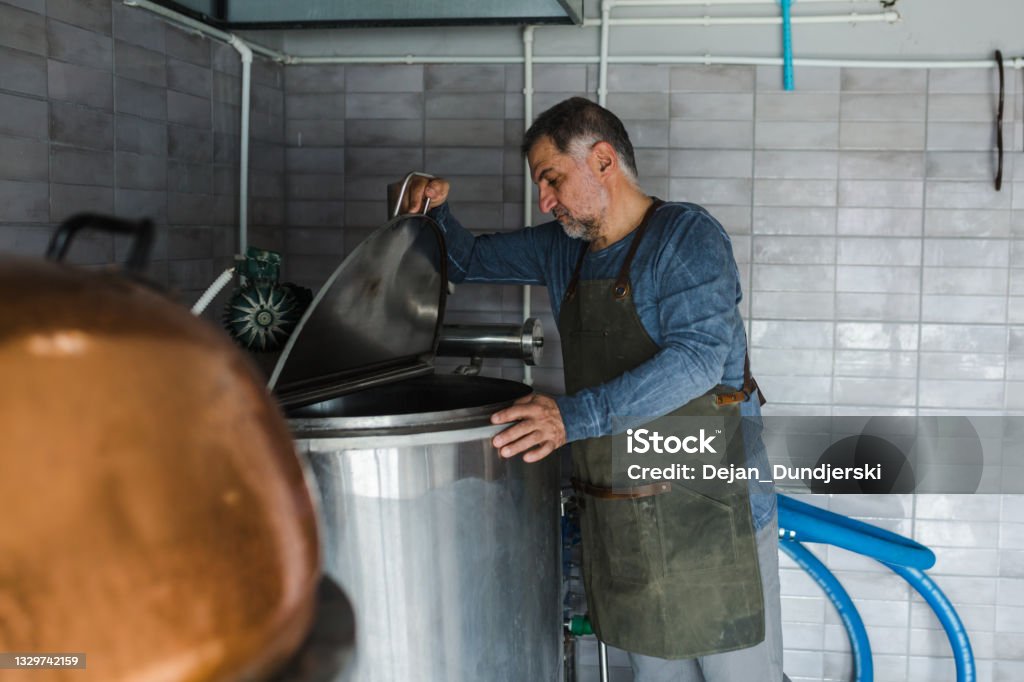 người đàn ông trong nhà máy bia thủ công nhỏ người đàn ông làm việc trong nhà máy bia thủ công nhỏ Ảnh chụp thùng