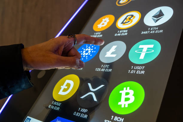 Valencia, Spain; 5th April 2022: A person uses a cryptocurrency ATM on the street. In crypto ATMs, also called BTMs, you can buy or sell cryptocurrency and it is becoming common to see them on the streets. Valencia, Spain; 5th April 2022: A person uses a cryptocurrency ATM on the street. In crypto ATMs, also called BTMs, you can buy or sell cryptocurrency and it is becoming common to see them on the streets. litecoin stock pictures, royalty-free photos & images