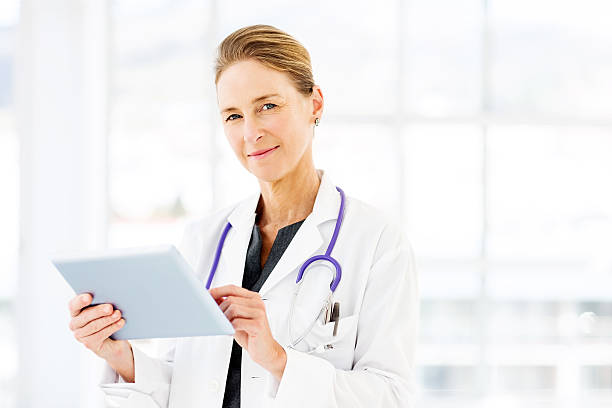 confident-female-doctor-using-tablet-computer-picture-id510798461