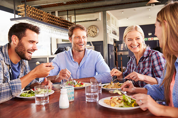 group of friends eating at a restaurant picture - The Path To Finding Better Cuisines