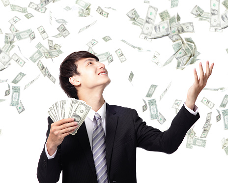 happy-suited-man-throwing-money-into-the-air-picture-id186261027
