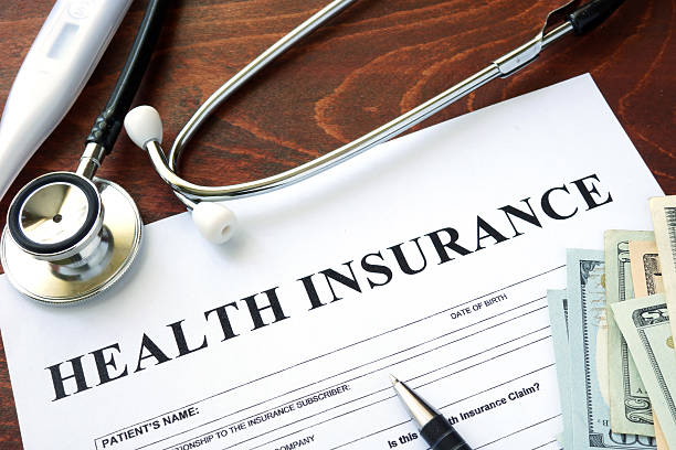 health insurance form and dollars on the table picture - Getting Down To Basics with Financial