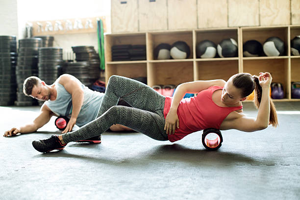 People in gym using support roller stock photo