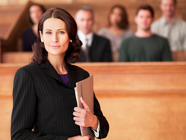 smiling lawyer holding file in courtroom picture - Questions About Attorneys You Must Know the Answers To