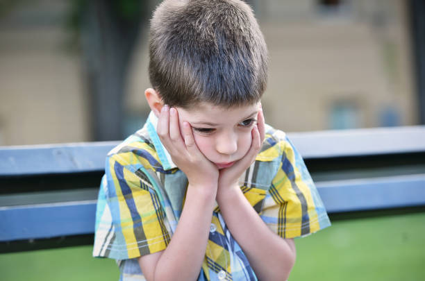 istock sad child boy sitting on a bench 1000002876