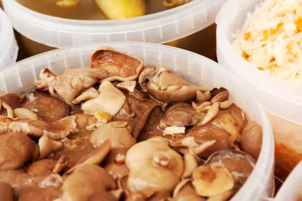 Photo of Pickled milk mushrooms and other food on a market stall
