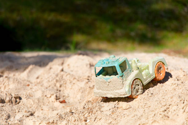 istock Abandoned old dirty children's toy car in sand.Selective focus 1000022816
