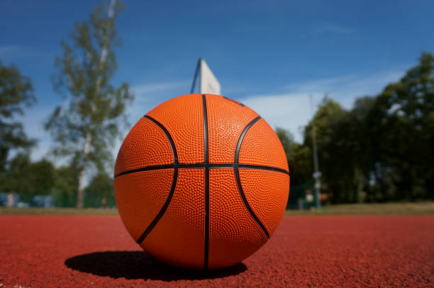 istock Orange basketball against the blue cloudy sky 1000032200