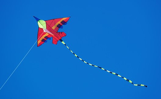 Flying a kite in beautifully blue skies.