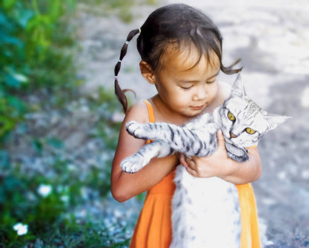 Two little girl cuddling cat in backyard