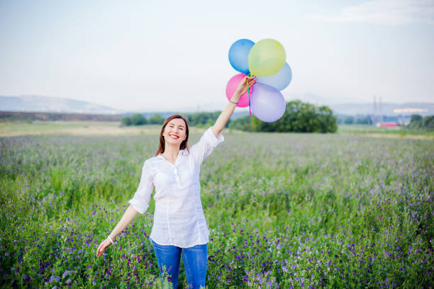 istock young woman holding balloons 1000064404