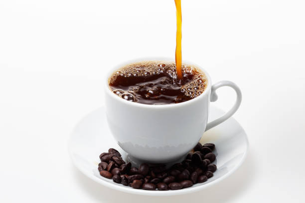 istock Pouring coffee into white coffee cup and beans on white background. 1000079230