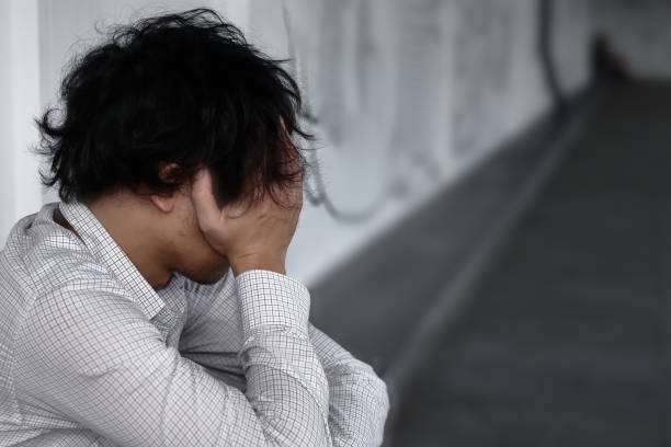 istock Frustrated stressed Asian man covering face with hands 1000098014