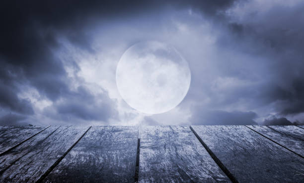 istock Halloween background. Spooky sky with full moon and wooden table 1000104762