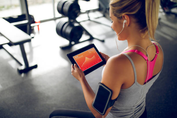 tracking ihre fortschritte mit fitness-app auf digital-tablette - gesunder lebensstil grafiken stock-fotos und bilder