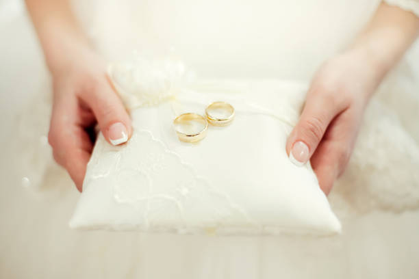 istock Bride holding pillow with golden wedding rings 1000109406