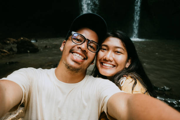 istock Young Couple Pose For Holiday Selfie, waterfall in Bali 1000127730