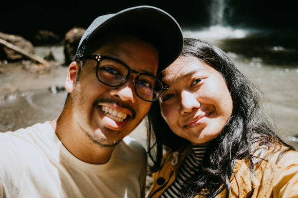 istock Couple taking selfie in the sunny day at waterfall 1000128224