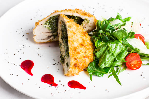 istock Breaded chicken fillet stuffed with spinach with fresh vegetables and herbs 1000160106