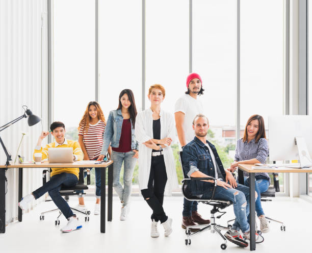 групповой портрет многоэтнической разнообразной уверенной бизнес-команды, стоящей и сидящей в современном офисе с копировальной площадью - team photo стоковые фото и изображения