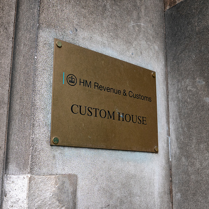 A metal sign on the wall outside HM Revenue & Customs 'Custom House' in London. Custom House in on the north bank of the River Thames.