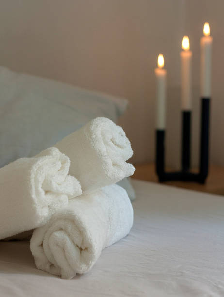istock white towels on a bed with candels in background 1000191182