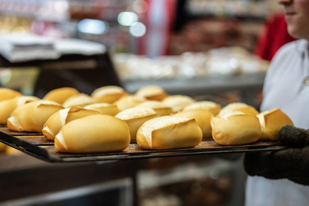 Baker pulling a tray with hot bread Bakery bun bread stock pictures, royalty-free photos & images