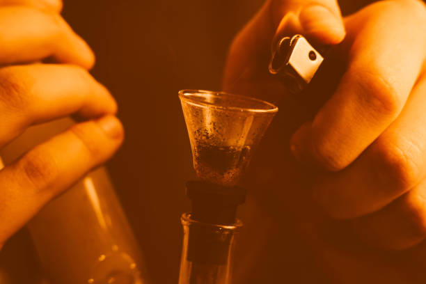 istock A man smokes cannabis weed, a joint and a lighter in his hands. Yellow toning 1000255214