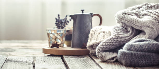 istock Knitted sweaters on a wooden background in the interior 1000277748