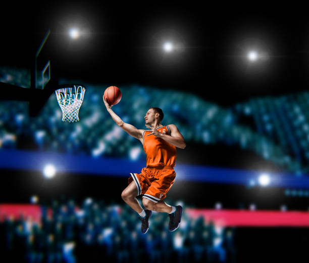 istock basketball player making slam dunk on basketball arena 1000302582