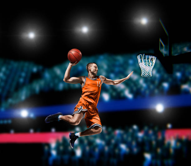 istock basketball player making slam dunk on basketball arena 1000302620
