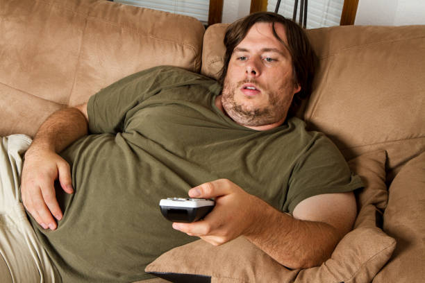 istock Fat lazy guy on the couch 1000315288