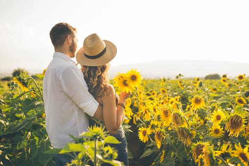 Couple enjoying summer time at sunflowers field