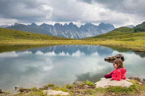 little girl is located on a small lake where the mountain is reflected. salfains lake in austria