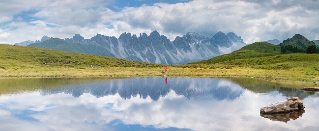 Panorama picture of the salfains lake in the austrian alps with the kalkkögel in the background little girl runs in the background