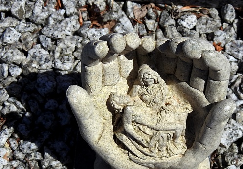 Grave ornament with hand holding Jesus and Mary