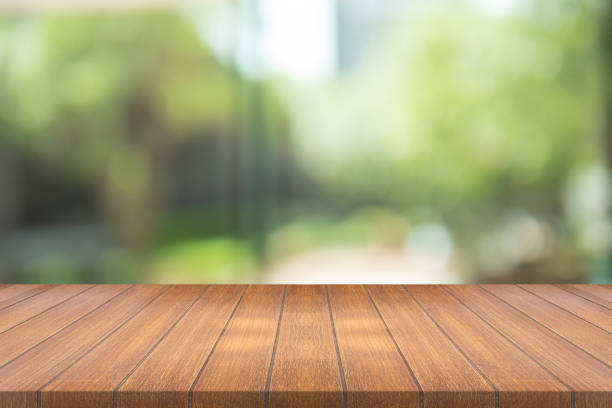 istock Empty wood table on blurred background copy space for montage your product or design , Blank brown board with abstract blurred green background. 1000400806