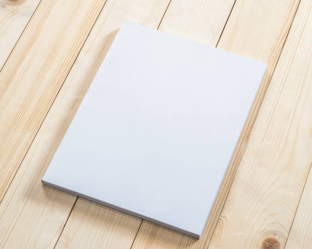 istock Blank book cover mockup template with page front side on white surface on wood table 1000406898