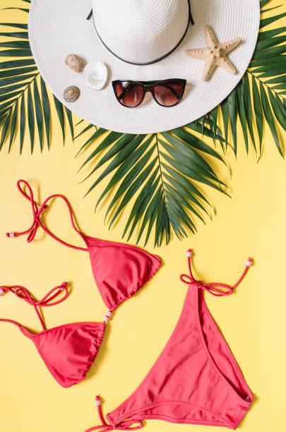 istock Beach apparel and tropical palm leaves arranged on yellow background 1000409960