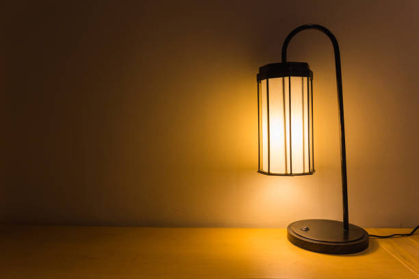 istock Classic table lamp on wooden wall and table background 1000494096