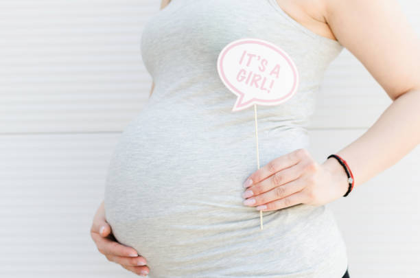 Its a girl props Cropped image of pregnant woman who announcement she's having a baby girl, using a booth prop. funny pregnancy announcements stock pictures, royalty-free photos & images