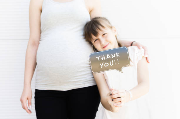 Close up of mother and cute llittle girl holding booth prop with thank you note