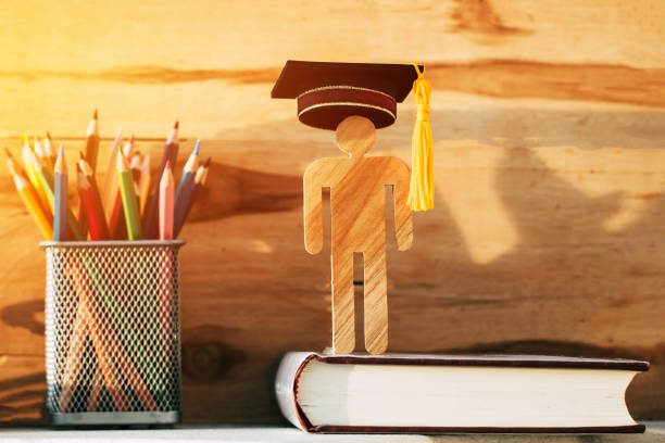 istock Graduate or Education knowledge learning study abroad international Ideas. Man Sign wood with Graduation celebrating cap pencil box on wood background show alternative studying Back to School Concept 1000509662