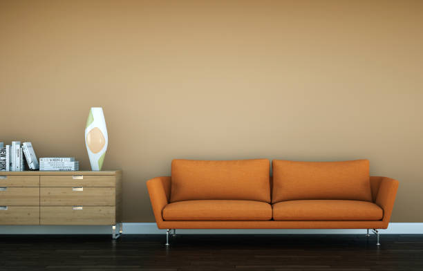 istock Bright room with orange sofa in front of a brown wall 1000595494