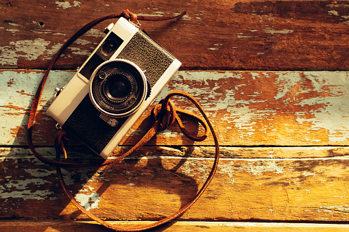 Photo of nostalgia - vintage film camera on old wooden background
