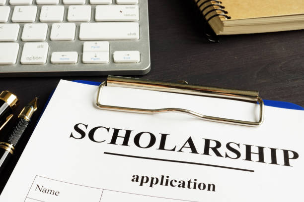 istock Scholarship application and money for education on a table. 1000661072