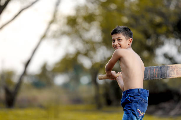 istock Rural Indian Child Playing Cricket 1000664698