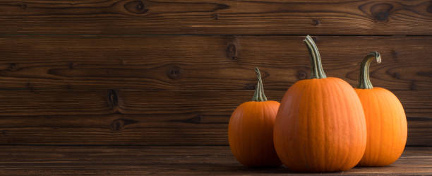 istock Pumpkins on wooden background 1000664906