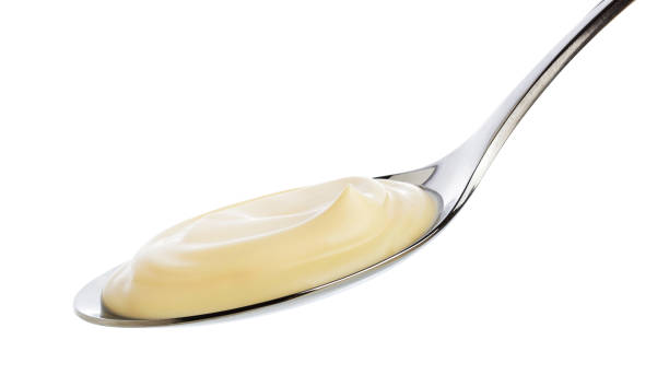 istock Sour cream in spoon isolated on white background with clipping path 1000682288