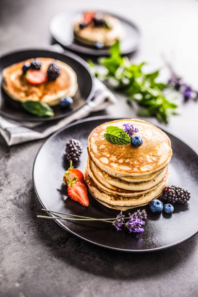 istock Pancakes with strawberries blackberries blueberries lavender and mint leaves. 1000694346